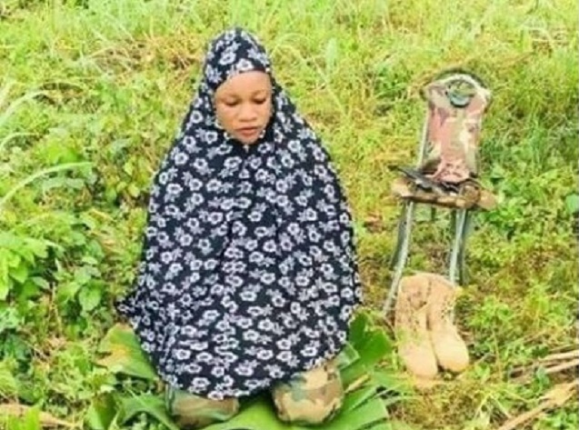 Viral Photo of Nigerian Female Soldier Praying With Her Rifle before Battlefield